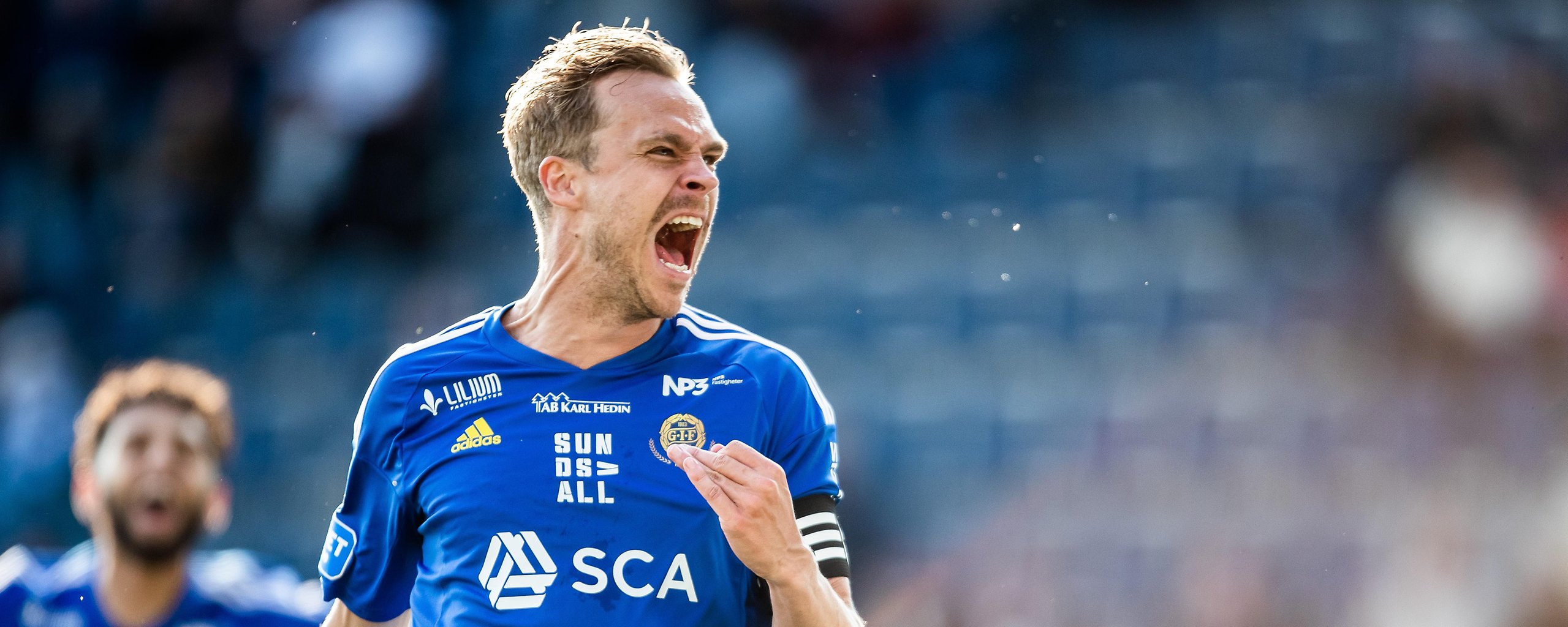 Pontus Engblom, fotbollsspelare iklädd blå matchtröja firar ett mål.
